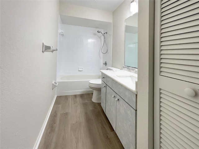 full bath featuring shower / tub combination, toilet, wood finished floors, vanity, and baseboards