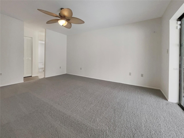 carpeted spare room with a ceiling fan