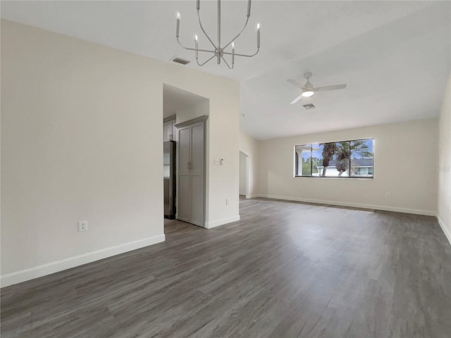 interior space with ceiling fan with notable chandelier, dark wood finished floors, visible vents, and baseboards