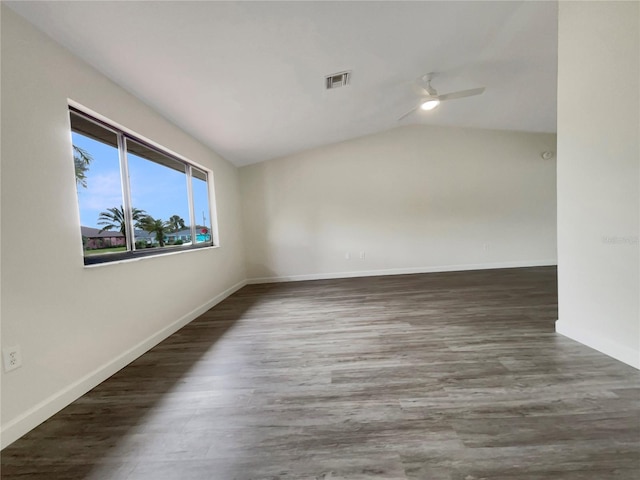 empty room with lofted ceiling, baseboards, visible vents, and wood finished floors