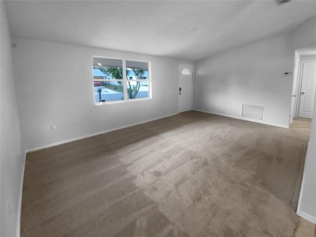 empty room with carpet flooring, visible vents, and baseboards