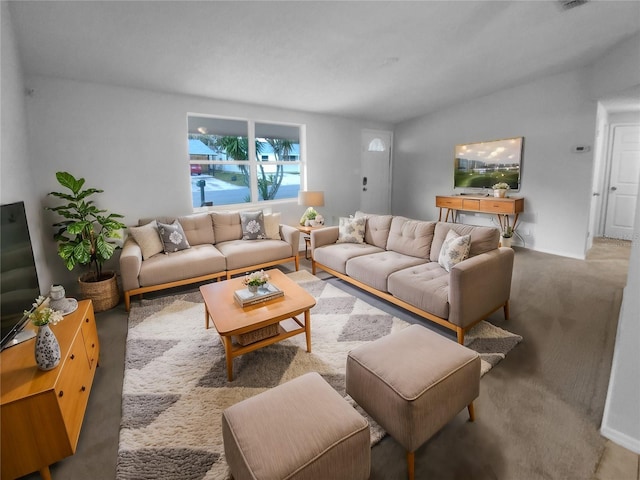 living area featuring carpet and vaulted ceiling