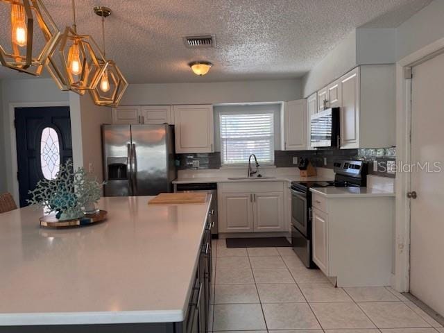 kitchen featuring light tile patterned floors, light countertops, visible vents, appliances with stainless steel finishes, and a sink