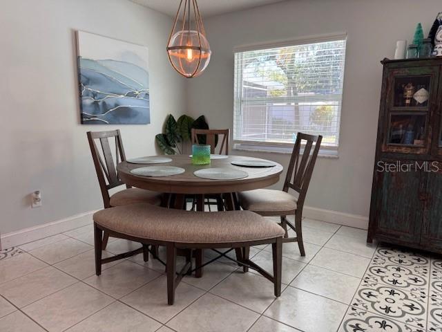 dining space featuring baseboards and light tile patterned floors