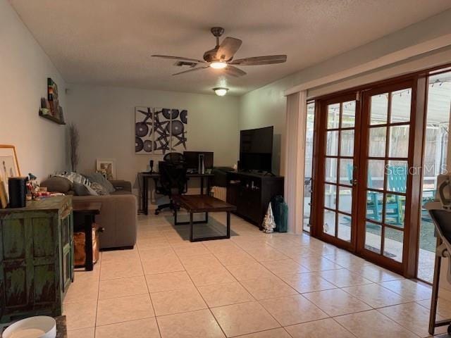 living area with french doors, ceiling fan, and light tile patterned floors