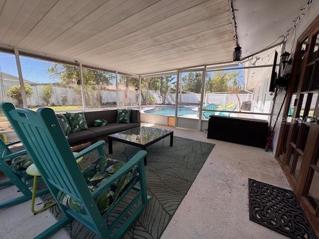 sunroom with wood ceiling and rail lighting