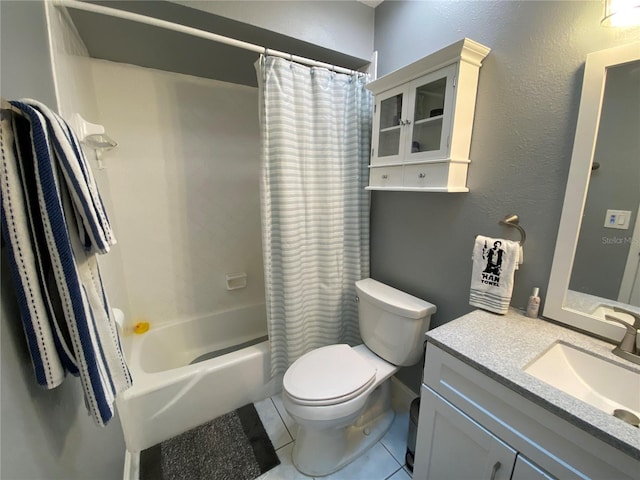 bathroom featuring a textured wall, toilet, vanity, tile patterned floors, and shower / bath combo