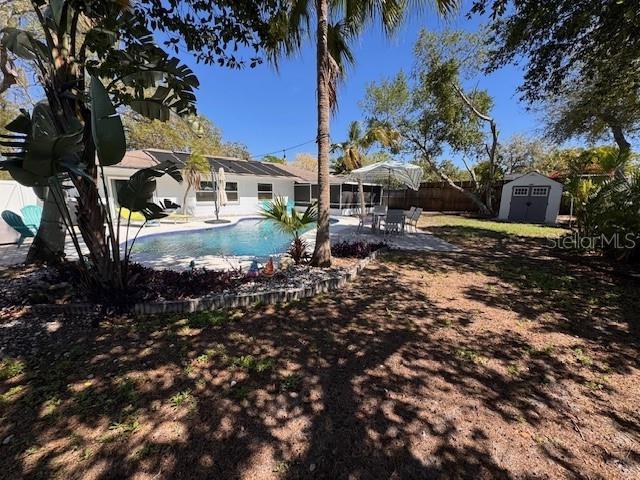 exterior space with fence private yard, a storage shed, an outdoor structure, and a patio