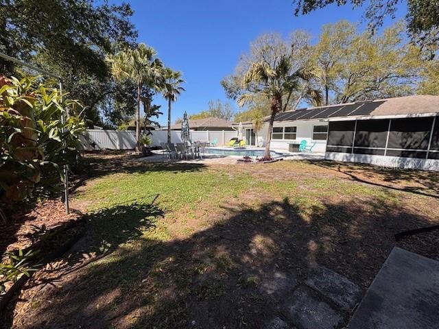 view of yard with a fenced in pool, a sunroom, fence, and a patio