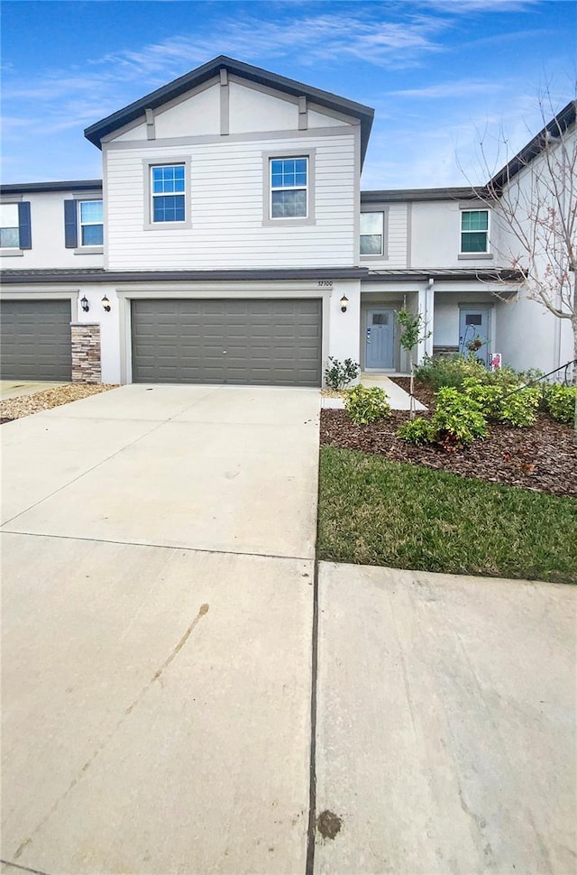 view of front of property featuring driveway, an attached garage, and stucco siding