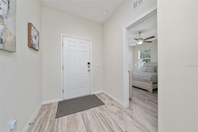 entryway with a ceiling fan, wood finished floors, visible vents, and baseboards