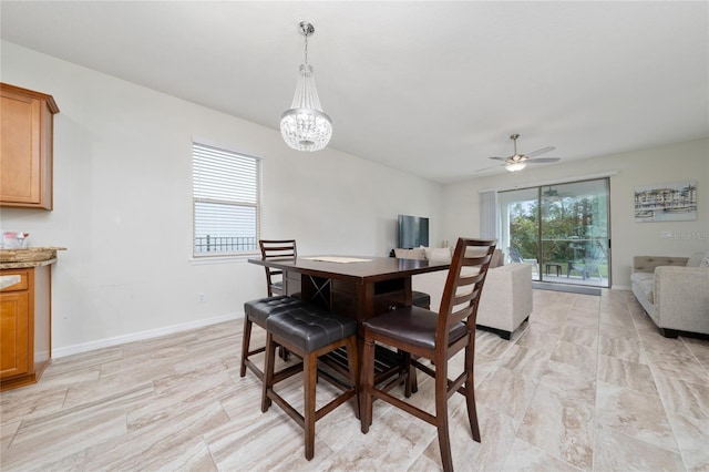 dining area featuring plenty of natural light, baseboards, and ceiling fan with notable chandelier