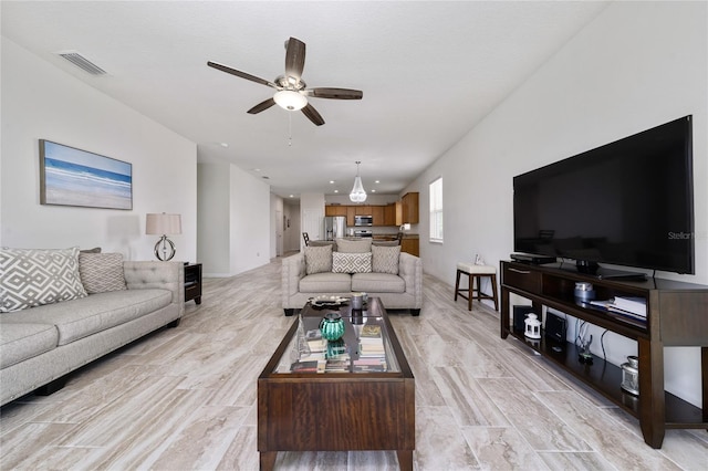 living area featuring visible vents and a ceiling fan