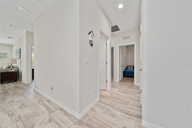 hall with baseboards and visible vents