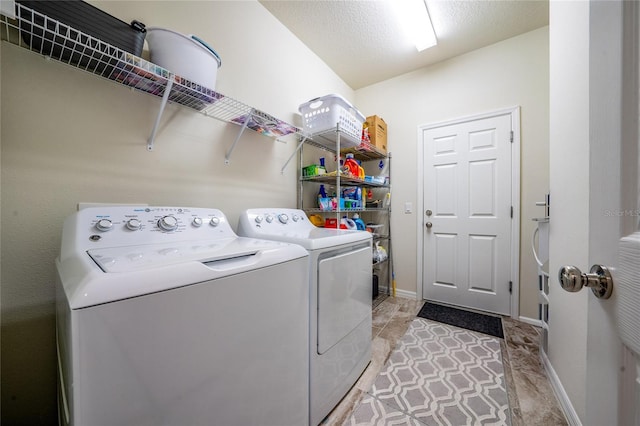 clothes washing area with washer and dryer, laundry area, and baseboards