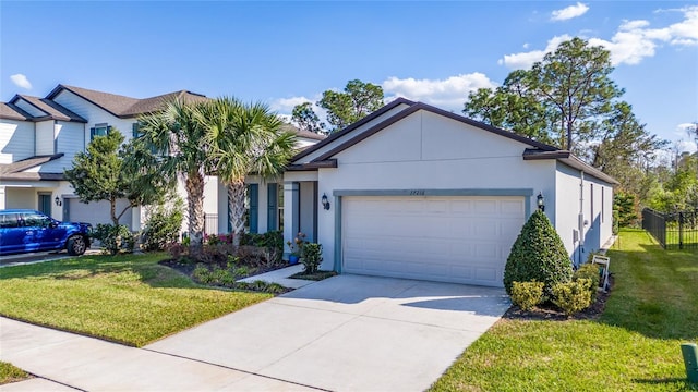 view of front facade with a garage, fence, concrete driveway, stucco siding, and a front lawn