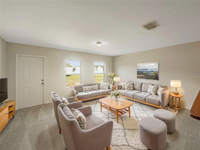 living room featuring a textured ceiling, carpet floors, and visible vents