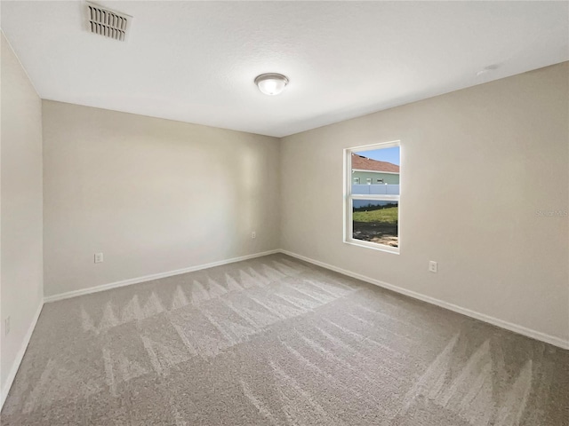 unfurnished room with carpet, baseboards, and visible vents