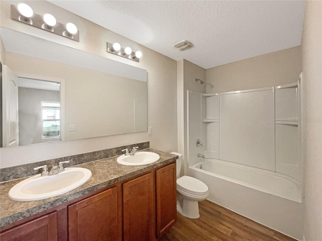 bathroom featuring a textured ceiling, wood finished floors, a sink, and toilet