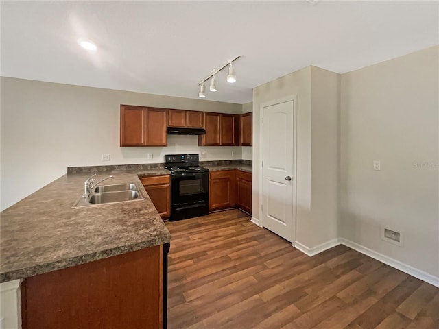 kitchen with a sink, under cabinet range hood, dark countertops, and black electric range oven