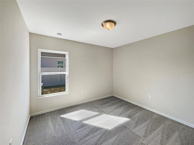 carpeted spare room with baseboards