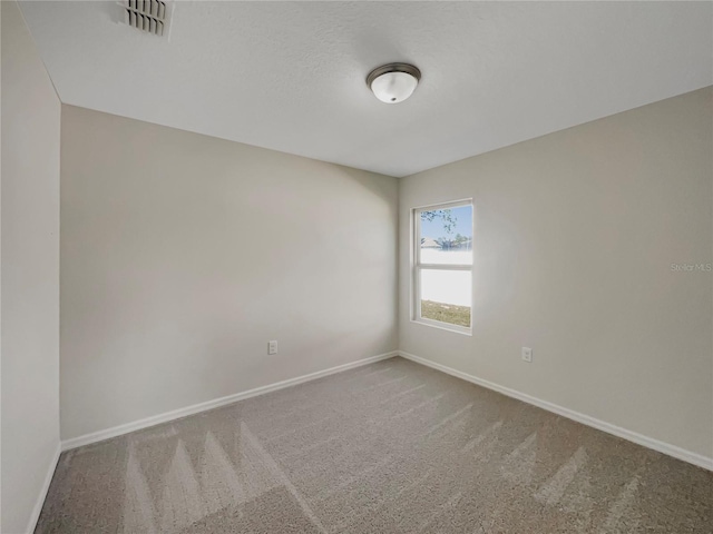 carpeted spare room with baseboards and visible vents