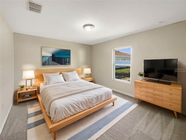 carpeted bedroom with visible vents and baseboards