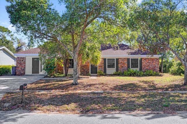 view of front of house featuring driveway and brick siding