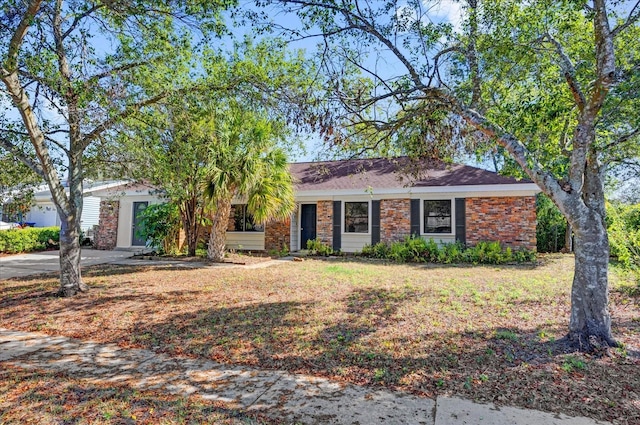 view of front facade with brick siding and a front yard