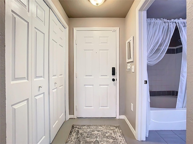 doorway to outside featuring baseboards and tile patterned floors