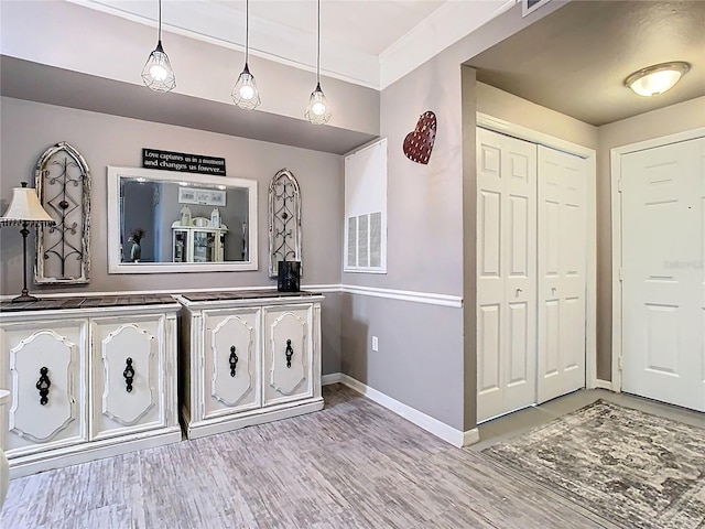 entrance foyer with visible vents, light wood-style flooring, and baseboards