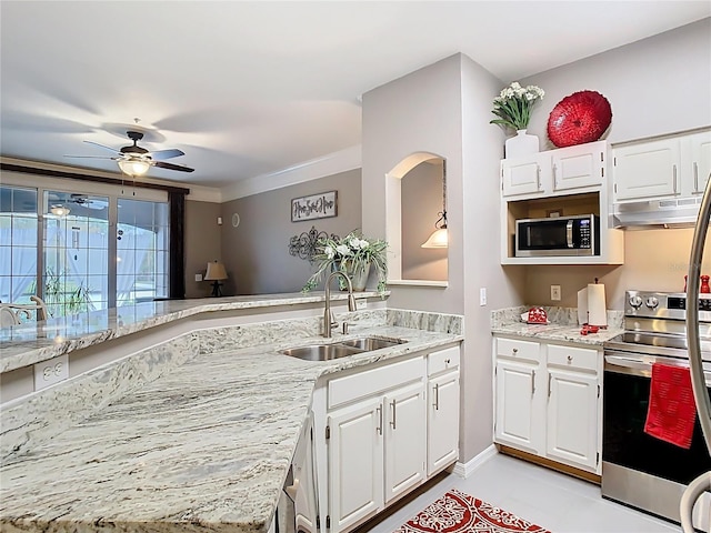 kitchen with light stone counters, under cabinet range hood, stainless steel appliances, a sink, and white cabinets