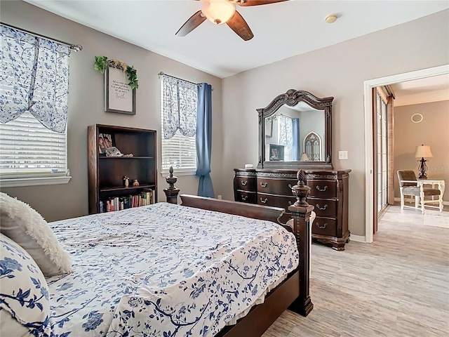 bedroom featuring light wood-type flooring, a ceiling fan, and baseboards