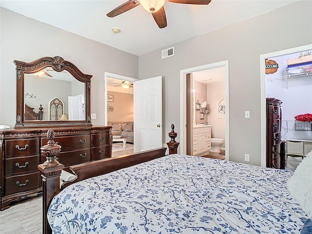 bedroom with a ceiling fan, a spacious closet, visible vents, and connected bathroom