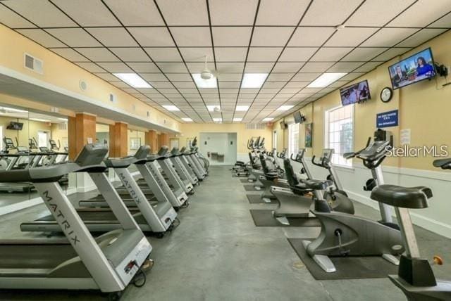 exercise room featuring a drop ceiling, visible vents, and baseboards