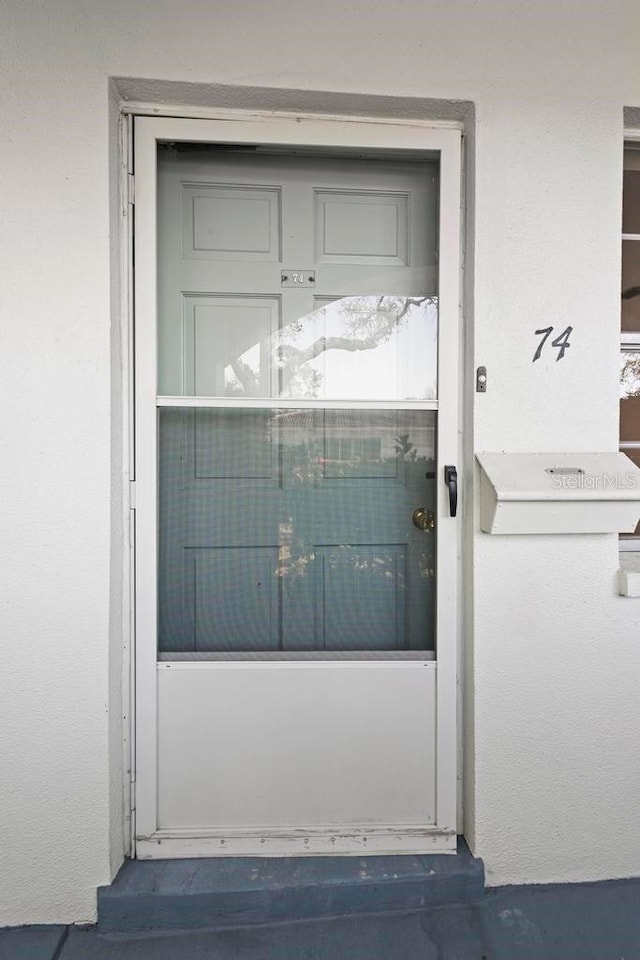 doorway to property with stucco siding