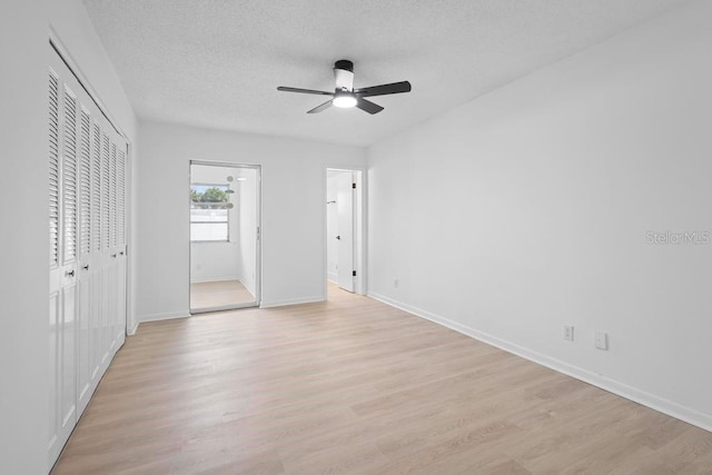 unfurnished bedroom with a textured ceiling, baseboards, and light wood-style floors