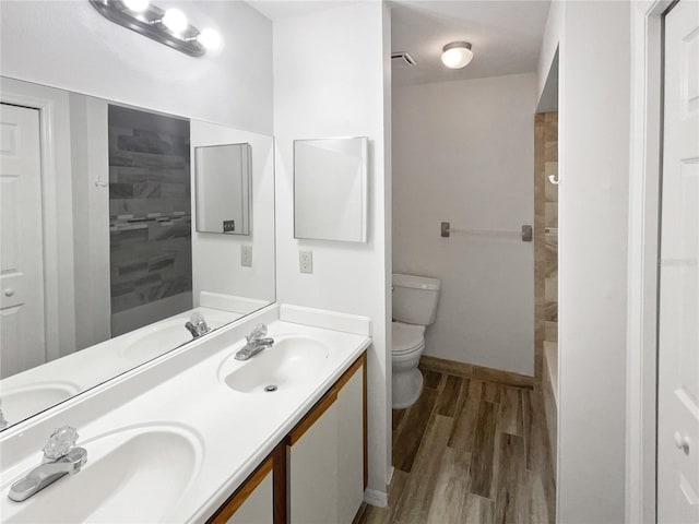 bathroom with wood finished floors, a sink, and toilet