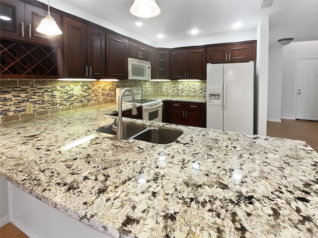 kitchen featuring white appliances, tasteful backsplash, glass insert cabinets, light stone countertops, and a sink
