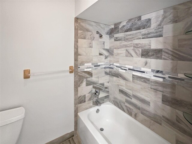 bathroom featuring  shower combination, baseboards, and toilet