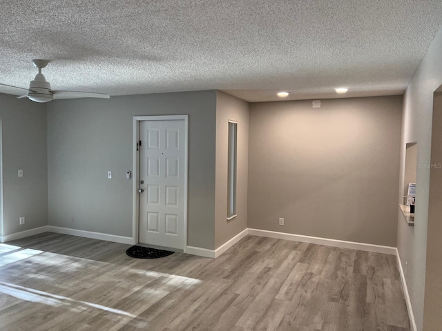 entrance foyer with light wood-style floors, baseboards, and a ceiling fan