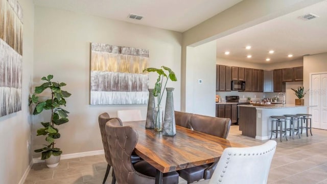 dining room featuring light tile patterned floors, baseboards, visible vents, and recessed lighting