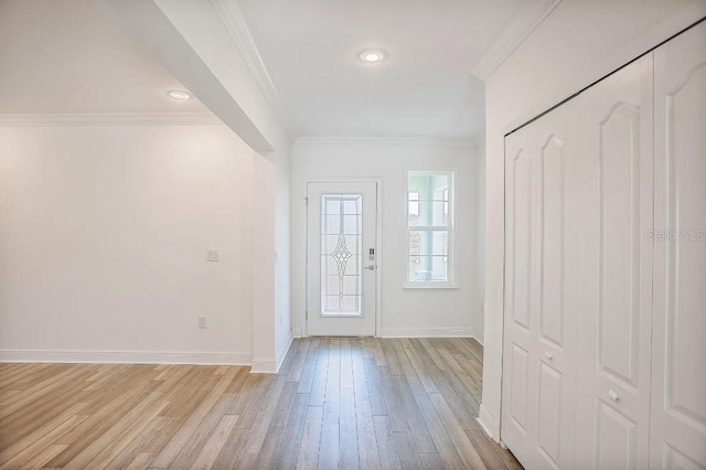 foyer entrance featuring baseboards, light wood finished floors, and crown molding