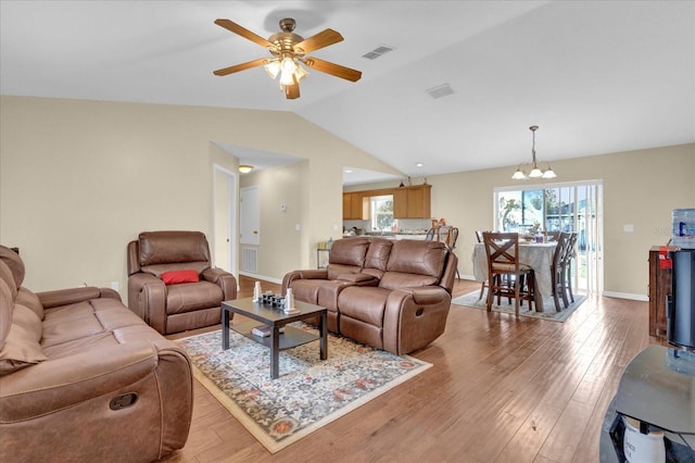 living room with light wood-type flooring, visible vents, and lofted ceiling