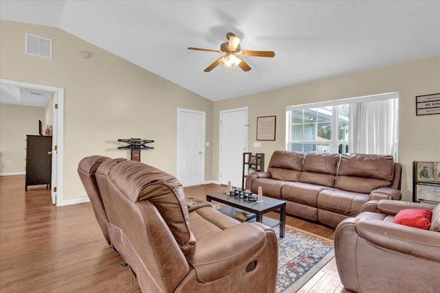 living area featuring lofted ceiling, wood finished floors, visible vents, and a ceiling fan