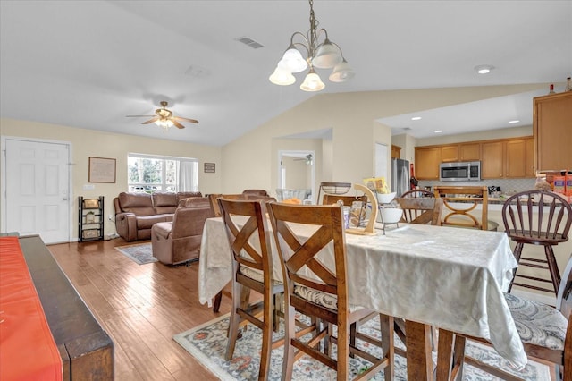 dining area featuring lofted ceiling, ceiling fan, visible vents, and light wood-style floors