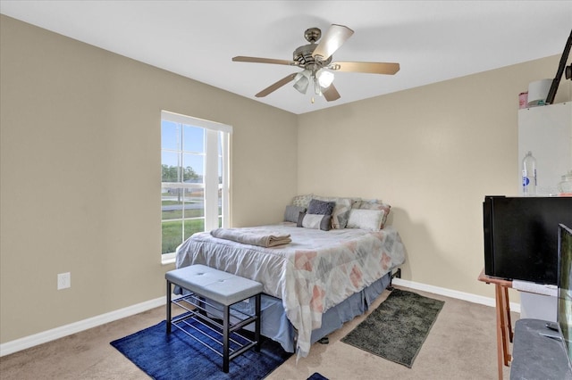 carpeted bedroom with a ceiling fan and baseboards