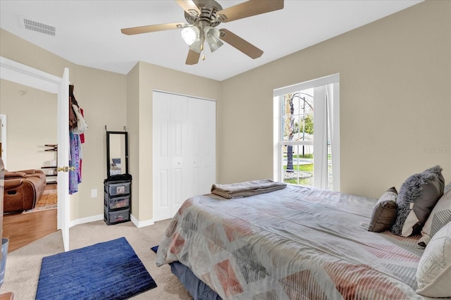 bedroom with ceiling fan, light carpet, visible vents, baseboards, and a closet