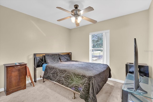 carpeted bedroom with ceiling fan and baseboards