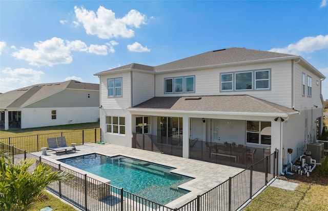 back of property featuring a fenced backyard, central air condition unit, roof with shingles, a lawn, and a patio area